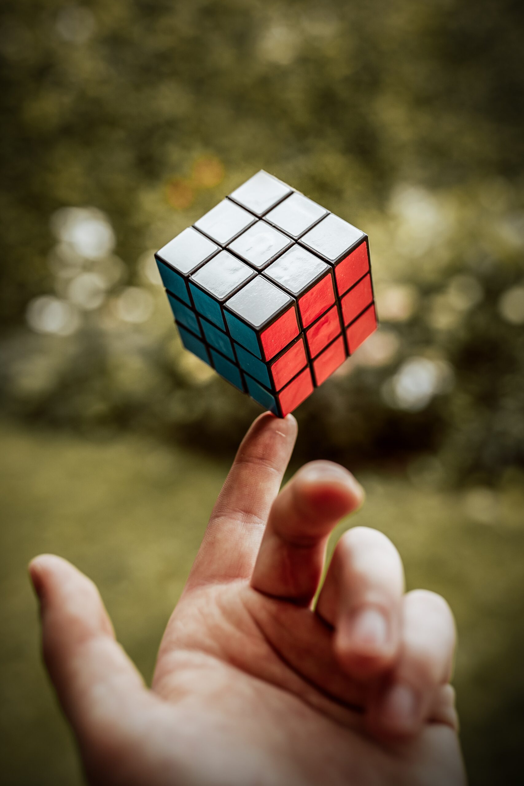 Freelancing with multiple clients - find your balance; Rubik's cube balanced on the index finger of a right hand.