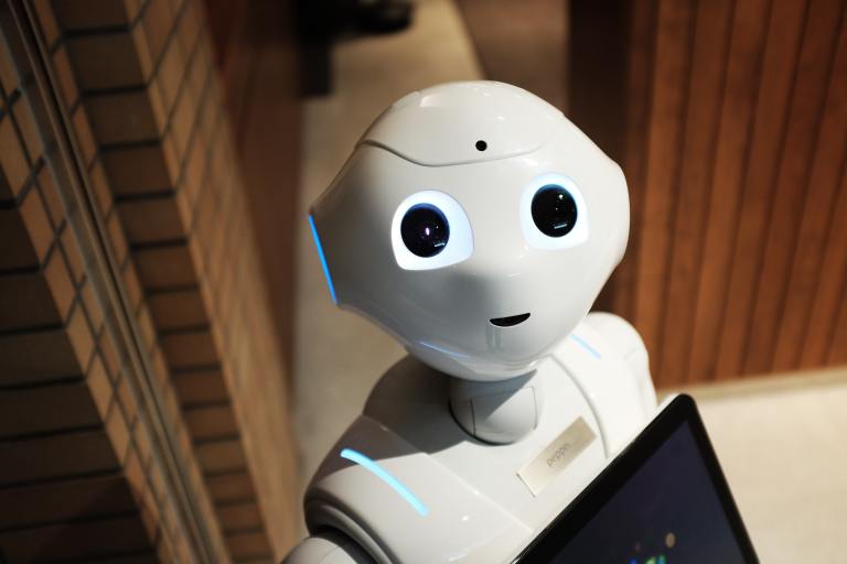 Picture of a white robot holding a computer