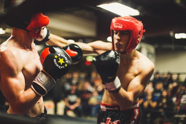When personalities and programing styles clash | Two men boxing with red soft helmets and black gloves on.