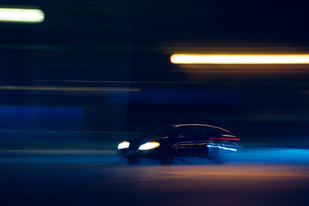 Swift developer job description sample | Darkly lit shot of a car speeding through a tunnel.