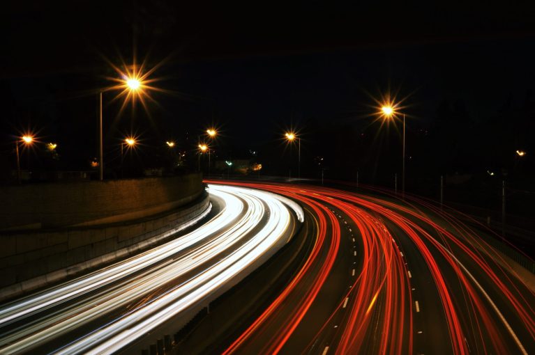 Best sites to hire Swift developers | Long exposure shot of a freeway with the lights of cars moving in long, drawn out lines.